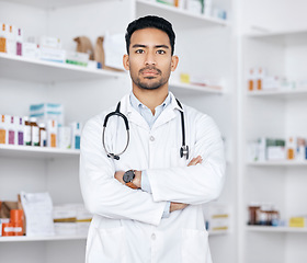 Image showing Pharmacist, man and arms crossed for healthcare service, medicine inventory and store management. Professional portrait of medical worker or asian doctor in pharmacy or clinic, pills or product shelf