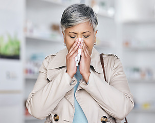 Image showing Sick, sneeze and mature woman in pharmacy, allergy or cold medicine in pharmaceutical health shop. Blowing nose, tissue and person in drug store for covid medication, medical asthma treatment or flu