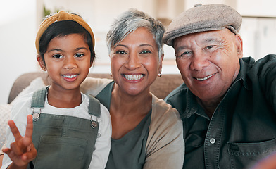 Image showing Peace sign selfie, smile and a girl with her grandparents on a sofa in the living room of their home closeup. Grandmother, grandfather and granddaughter together for a photograph during a visit