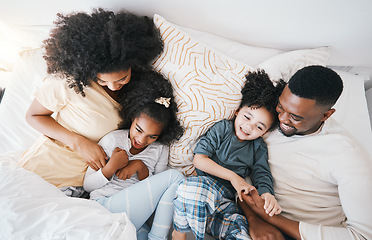 Image showing Mom, father and kids in bed with tickling, comic joke and laugh in top view, care and love in family house. Black man, mother and daughter with smile, play game and crazy in bedroom, morning and home