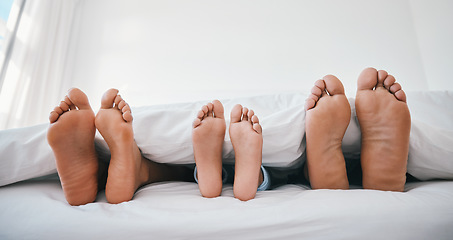 Image showing Sleeping, feet and family in a bed with love, relax and resting in comfort in their home together. Barefoot, care and child with mom, father and security in bedroom for sleep, bonding and weekend nap