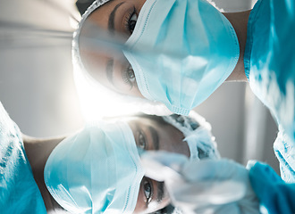 Image showing Low face, looking and doctors in surgery for healthcare, working or help in cardiology. Inspection, hospital and a nurse team or surgeon in theater for a medical procedure or operation or exam