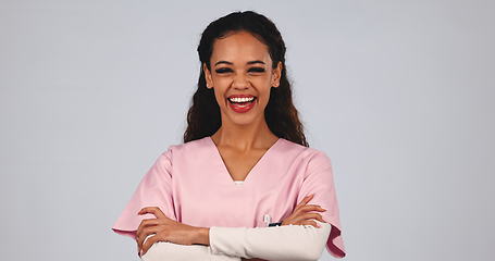 Image showing Medical nurse, laughing and a woman in studio with a smile, pride and arms crossed. A happy and friendly female healthcare worker or caretaker on grey background for wellness, medicine and portrait