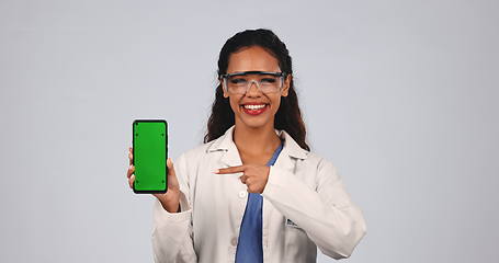 Image showing Woman, scientist and green screen of phone in studio for advertising, research app or information on white background. Portrait, science or pointing to tracking markers on smartphone for data results