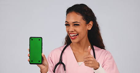 Image showing Doctor, thumbs up and phone green screen for medical services, registration and like, yes or ok in studio. Face of healthcare nurse or woman with mobile app and tracking marker on a white background