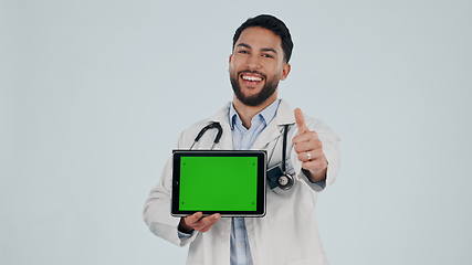 Image showing Doctor, tablet green screen and thumbs up, success or healthcare support, thank you and like emoji in studio. Face of medical man for digital telehealth, yes and tracking marker on a white background