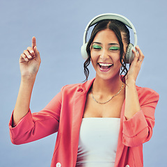 Image showing Music, headphones and happy woman dance in studio with podcast, track or audio subscription on blue background. Face, smile and lady model with freedom, energy or moving to radio or feel good podcast