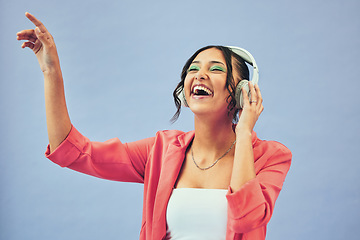 Image showing Fashion, music and happy woman dance in studio with trendy, clothes and feel good audio on blue background. Style, smile and female model with freedom, energy or moving to radio, streaming or podcast
