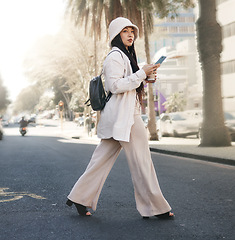 Image showing Woman crossing street with phone, walking in city and travel with location app, social media and streetwear. Influencer, streamer or gen z girl with urban fashion, smartphone and direction in road.