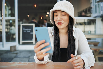 Image showing Student, travel and woman with phone at a cafe for social media, texting or chatting in a city. Smartphone, app and lady influencer at coffee shop for content creation, podcast or traveling blog post