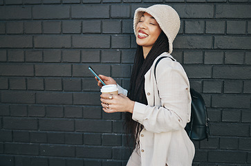 Image showing Happy woman with phone, brick wall and urban fashion, typing social media, chat and laughing. Streetwear, gen z girl or online influencer with smartphone for content creation and meme communication.