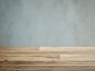 Image showing Wooden table and grey wall 