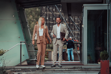 Image showing Modern business couple after a long day's work, walking together towards the comfort of their home, embodying the perfect blend of professional success and personal contentment.