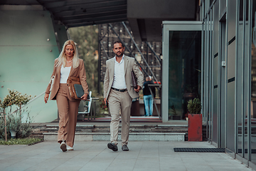 Image showing Modern business couple after a long day's work, walking together towards the comfort of their home, embodying the perfect blend of professional success and personal contentment.