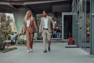 Image showing Modern business couple after a long day's work, walking together towards the comfort of their home, embodying the perfect blend of professional success and personal contentment.