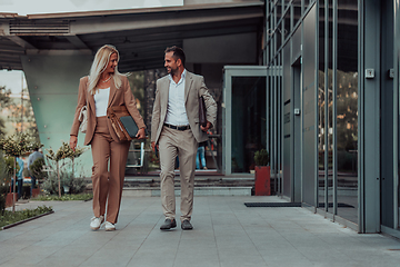 Image showing Modern business couple after a long day's work, walking together towards the comfort of their home, embodying the perfect blend of professional success and personal contentment.