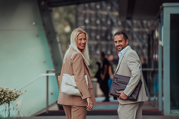 Image showing Modern business couple after a long day's work, walking together towards the comfort of their home, embodying the perfect blend of professional success and personal contentment.