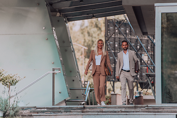 Image showing Modern business couple after a long day's work, walking together towards the comfort of their home, embodying the perfect blend of professional success and personal contentment.