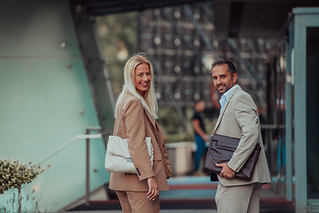 Image showing Modern business couple after a long day's work, walking together towards the comfort of their home, embodying the perfect blend of professional success and personal contentment.