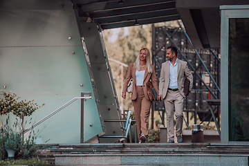 Image showing Modern business couple after a long day's work, walking together towards the comfort of their home, embodying the perfect blend of professional success and personal contentment.