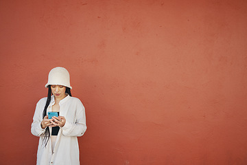 Image showing Mockup, wall and woman with phone in a city for travel, search or location map on orange background. Smartphone, app and lady fashion influencer outdoor on social media, blog podcast content creation