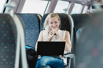 Image showing Woman smiling while travelling by train.