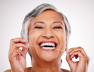 Image showing Senior woman, dental floss and studio portrait for healthcare, beauty and cleaning mouth by white background. Mature female model, teeth whitening and thread for self care, breath and healthy smile
