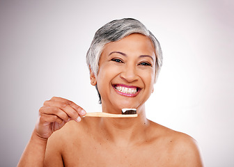 Image showing Senior woman, portrait and toothbrush in dental, cleaning or hygiene against a studio background. Happy mature female person smile with toothpaste for tooth whitening, mouth or oral and gum care