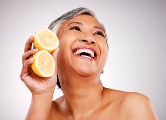 Image showing Senior, happy woman and lemon for vitamin C, skincare or natural nutrition against a studio background. Mature female person smile with organic citrus fruit for collagen, detox or diet on mockup