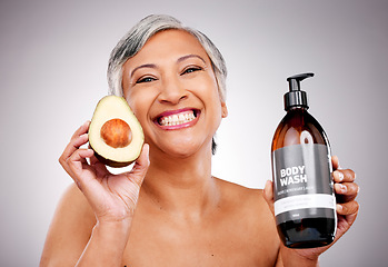 Image showing Senior woman, avocado and studio portrait for bottle, product or soap for body wash by white background. Mature female model, fruit and liquid for cleaning, beauty and skincare with organic cosmetics