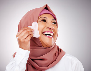 Image showing Skin, gua sha stone and a muslim woman closeup in studio on a gray background for beauty. Skincare, smile and natural with a happy mature arab person massaging her face for antiaging treatment