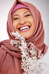 Image showing Happy muslim woman, portrait and face with hijab, plant or fashion against a studio background. Islam, female person and scarf with smile in happiness for religion, stylish clothing or natural beauty