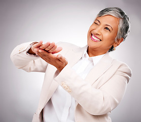 Image showing Money, hands and wink by senior business woman in studio happy with investment, growth or payment on grey background. Profit, success and elderly female CEO smile for 401k, emoji or loan promotion