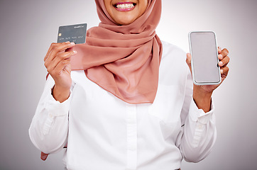 Image showing Woman, credit card and phone screen for online shopping, muslim fashion marketing and e commerce in studio. Islamic customer in hijab, mobile mockup and banking app for payment on a white background