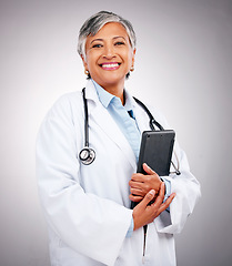 Image showing Senior, happy woman and portrait of doctor with tablet in healthcare research against a studio background. Mature female person or medical professional smile with technology for health advice or help