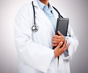 Image showing Doctor, technology and hands with tablet in studio for healthcare services, telehealth support and help. Closeup of professional medical worker, digital connection and consulting on grey background