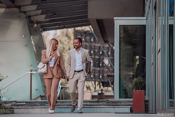 Image showing Modern business couple after a long day's work, walking together towards the comfort of their home, embodying the perfect blend of professional success and personal contentment.