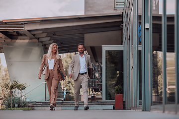 Image showing Modern business couple after a long day's work, walking together towards the comfort of their home, embodying the perfect blend of professional success and personal contentment.