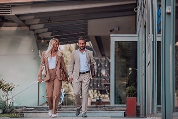 Image showing Modern business couple after a long day's work, walking together towards the comfort of their home, embodying the perfect blend of professional success and personal contentment.