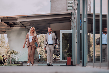 Image showing Modern business couple after a long day's work, walking together towards the comfort of their home, embodying the perfect blend of professional success and personal contentment.