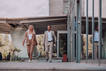 Image showing Modern business couple after a long day's work, walking together towards the comfort of their home, embodying the perfect blend of professional success and personal contentment.