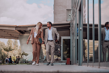 Image showing Modern business couple after a long day's work, walking together towards the comfort of their home, embodying the perfect blend of professional success and personal contentment.