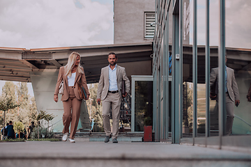 Image showing Modern business couple after a long day's work, walking together towards the comfort of their home, embodying the perfect blend of professional success and personal contentment.