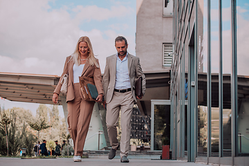 Image showing Modern business couple after a long day's work, walking together towards the comfort of their home, embodying the perfect blend of professional success and personal contentment.