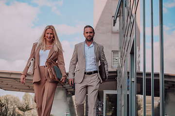 Image showing Modern business couple after a long day's work, walking together towards the comfort of their home, embodying the perfect blend of professional success and personal contentment.