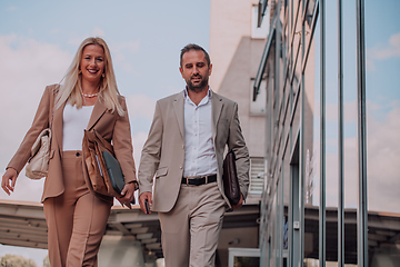 Image showing Modern business couple after a long day's work, walking together towards the comfort of their home, embodying the perfect blend of professional success and personal contentment.