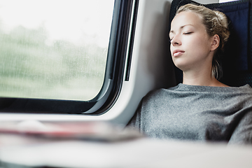 Image showing Lady traveling napping on a train.