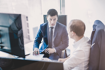 Image showing Two businessmen discussing a bisiness problem at meeting in trading office.