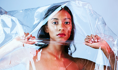 Image showing Plastic, woman and portrait with art, makeup and creativity in studio with cosmetics. Blue background, female person and packaging with unique aesthetic and skin glow with confidence and gloss