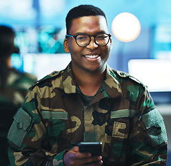 Image showing Portrait, phone and a military black man in a control room for surveillance, communication or networking. Face, smile and a confident young army soldier using a mobile while in a camouflage uniform